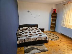 a bedroom with a bed and a blue wall at Cazare la mare Casa Realis Ovidiu in Ovidiu
