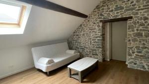 ボンヌヴィルにあるAppartement cosy et calmeの石壁のリビングルーム(ソファ付)
