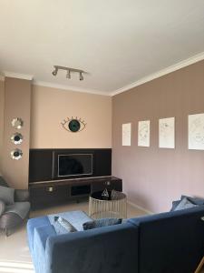 a living room with a blue couch and a tv at Seanest Greencoast in Himare
