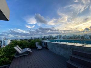 a rooftop deck with two chairs and a swimming pool at Exclusivo Monoambiente Beni in Santa Cruz de la Sierra
