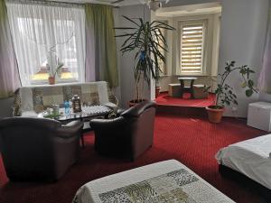 a bedroom with a couch and chairs and a table at Pokoje Goscinne in Orzesze