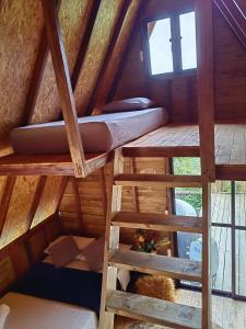 an attic room with two bunk beds and a window at Cabaña trébol del campo in Ebéjico +9 photos