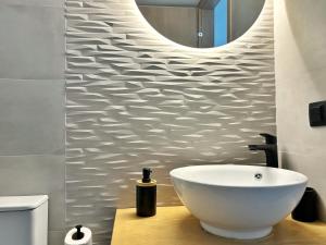 a bathroom with a white bowl sink and a mirror at Bamboo House Syros 2 in Ermoupoli +4 photos
