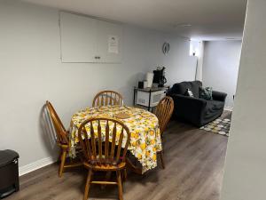 a dining room with a table and chairs and a couch at Cozy basement 2 bedroom 2 bath with parking in Richmond Hill +15 photos