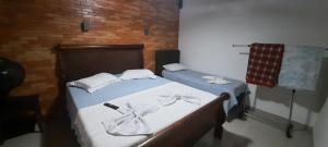 a bedroom with a bed with white sheets and bows at Hotel Pousada Don Ruan in Ponta Grossa