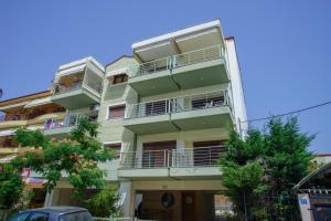 an apartment building with balconies and trees at Work of Art apartment in Nea Michaniona in Néa Michanióna