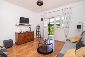 un soggiorno con un divano e una TV di House Mirna a Rogoznica (Rogosnizza)