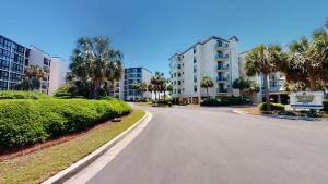 an empty street in a apartment complex with palm trees at Litchfield By the Sea 3BR Tranquil Retreat in Pawleys Island