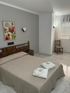 a bedroom with a bed with two white towels on it at Hotel Xacobeo in Outeiro
