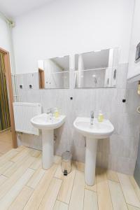 a bathroom with two white sinks in a room at Hostel Graffiti in Kraków