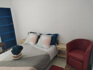 a bedroom with a bed and a red chair at Les Tilleuls in Vorey