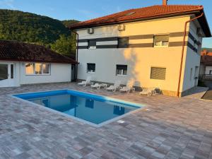 a swimming pool in front of a house at Althea Home & Wellness in Bihać