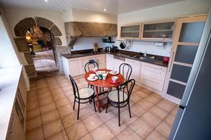 a kitchen with a table and chairs in a room at la Métairie du Grand Ker in Plougasnou