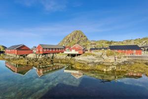 a small town with red buildings on a body of water at Waterfront Twin Cabin in Stamsund