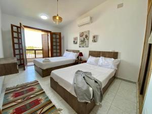 una camera da letto con due letti e una finestra di Marina 5 Resort a El Alamein