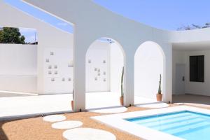 a villa with a swimming pool and white walls at Roka Hotel Boutique in Boa Vista