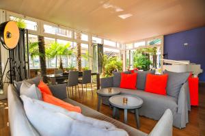 a living room with a gray couch and orange pillows at Eco Hotel Cleofe in Caorle