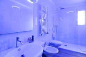 a white bathroom with a sink and a toilet at Eco Hotel Cleofe in Caorle