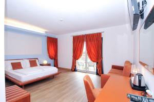 a bedroom with a bed and a couch and a table at Eco Hotel Cleofe in Caorle