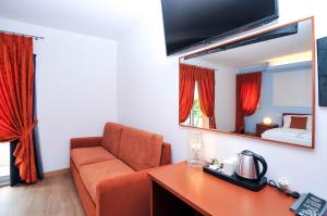 a living room with a couch and a mirror at Eco Hotel Cleofe in Caorle