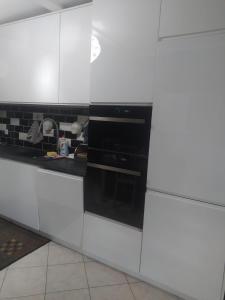 a kitchen with white cabinets and an oven at Bajkowy Dom in Mielno