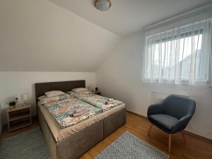 a bedroom with a bed and a blue chair at Barka Vendégház Tisza-tó in Abádszalók