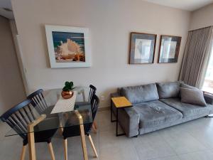 a living room with a table and a couch at Book Santos – Unlimited 1808 c/ Sacada Panorâmica in Santos +37 photos
