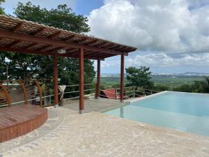 a swimming pool with a pergola and a swimming poolvisor at ADA MARINA, hotel campestre con la mejor vista a Cartagena in Turbaco