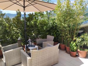 a patio with chairs and an umbrella and plants at Bellini's House in Montecatini Terme