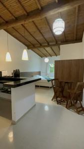 cocina con encimera y sillas en una habitación en Recanto Mucugê, en Porto Seguro