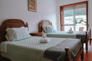 a bedroom with two beds with stuffed animals on them at Férias em Cerveira in Vila Nova de Cerveira