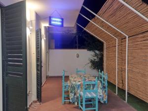 a room with a table and two blue chairs at BEACH HOUSE casavacanze in Reggio di Calabria