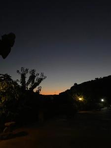 a sunset in the sky with a tree in the foreground at MonteSoprano Agriturismo - Resort - Spa - Gym -Camping - Suite in Capizzi