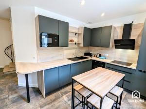 una cucina con armadi blu e tavolo in legno di Les Chênes - Climatisation - Spacieux - Nature a Boigny-sur Bionne