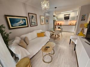 Una sala de estar con un sofá blanco y una mesa. en Apto La Mimosa - Salou, en Salou