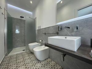 a bathroom with a sink and a toilet and a shower at Pizzuco holiday rooms in Montallegro