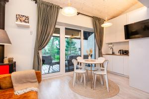 eine Küche und ein Wohnzimmer mit Tisch und Stühlen in der Unterkunft Pajūrio namelis FAMILY BEACH HOUSE su baseinu in Palanga
