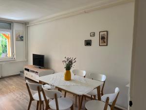 a white dining room with a table and chairs at Jó hely in Balatonalmádi