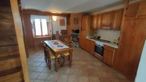 a kitchen with wooden cabinets and a small table in it at Gran Severino in Fabbrica Curone