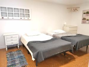 two twin beds in a room with a rug at Villa Amor Perfeito in Vila do Conde