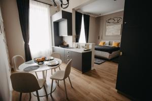 a kitchen and a living room with a table and chairs at Apartament lux ultracentral in Arad +17 photos