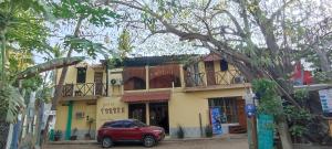 a red car parked in front of a building at Hotel Hostal Teresa in Zipolite