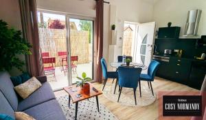 a living room with a blue couch and a table at Cosy Normandy - 01 in Bois-Jérôme-Saint-Ouen