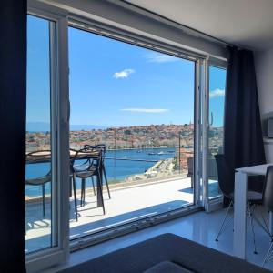 a room with a large window with a view of the water at Design penthouse 5 in Mali Lošinj