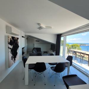 a living room with a white table and chairs at Design penthouse 5 in Mali Lošinj