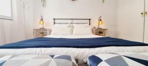 a bedroom with a large bed with blue and white sheets at BEACH HOUSE AGUILAS - Excelente Ubicacion!! Centro con Vistas Playa Delicias con Aire in Águilas +80 photos