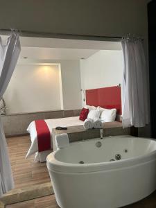 a bathroom with a bath tub in front of a bed at Zújmú Business Boutique Hotel in Aguascalientes +125 photos