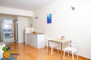 a kitchen with a small table and a refrigerator at pineapple hospitality in Mayaguez
