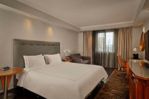 a hotel room with a large white bed and a desk at Park Plaza Victoria London in London