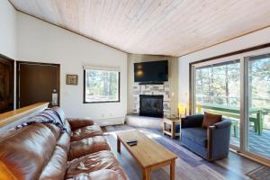 a living room with a leather couch and a fireplace at Bay Point Hillside 15D in Whitefish